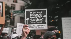A participant holds up a sign with a quote from St. Paul VI at a June 2020 rally in Atlanta. Credit: Maria Oswalt via Unsplash.