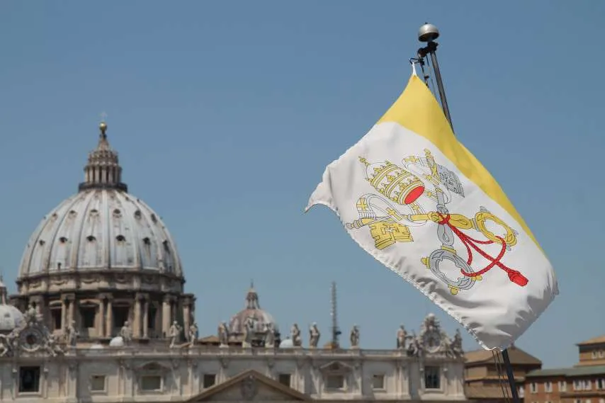 The flag of Vatican City with St. Peter's Basilica in the background. Credit: Bohumil Petrik/CNA