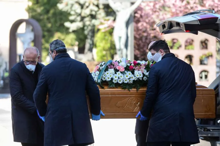 Undertakers wearing a face mask carry coffin in a cemetary in Bergamo, Italy on March 16, 2020. Credit: AFP via Getty Images