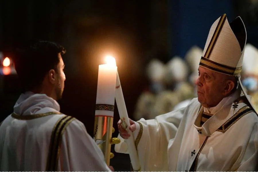 Pope Francis lights a candle at the Easter Vigil Mass in St. Peter's Basilica on April 3, 2021. Credit: Vatican Media/CNA.