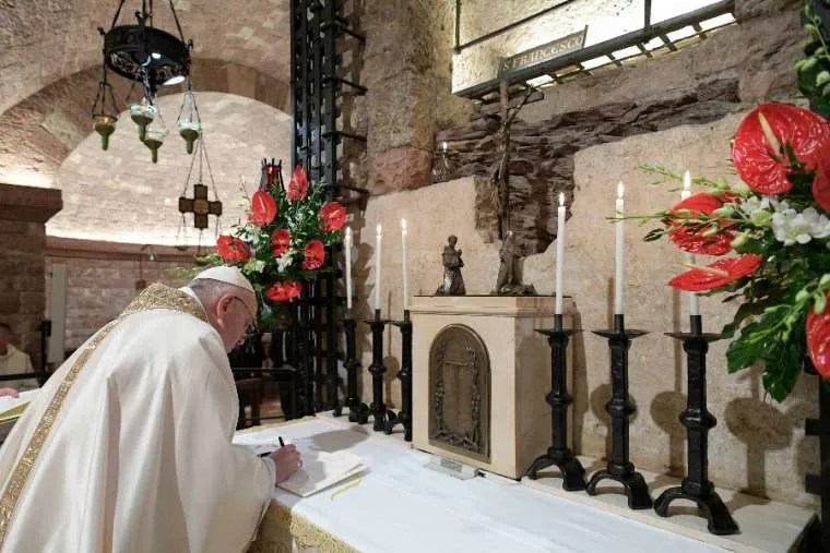 Pope Francis signs his new encyclical, Fratelli tutti, on the altar before the tomb of St. Francis of Assisi on Oct. 3, 2020. / Vatican Media.