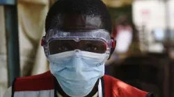 A health worker wears protective gear at a health screening facility in a Ugandan town bordering DRC. / Credit: Isaac Kasamani / AFP / Getty Images.