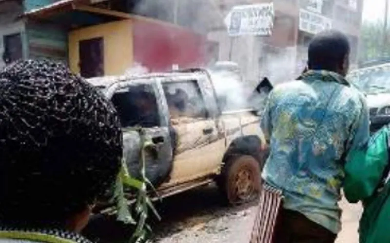Civilians walk past burning vehicles in Elak town, Northwest Cameroon Credit: Denis Hurley Peace Institute