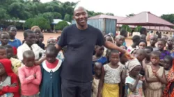 Pastor Solomon Folorunsho, Coordinator of Home for the Needy in Nigeria’s Benin State poses with a section of displaced children at the camp. Credit: Denis Hurley Peace Institue