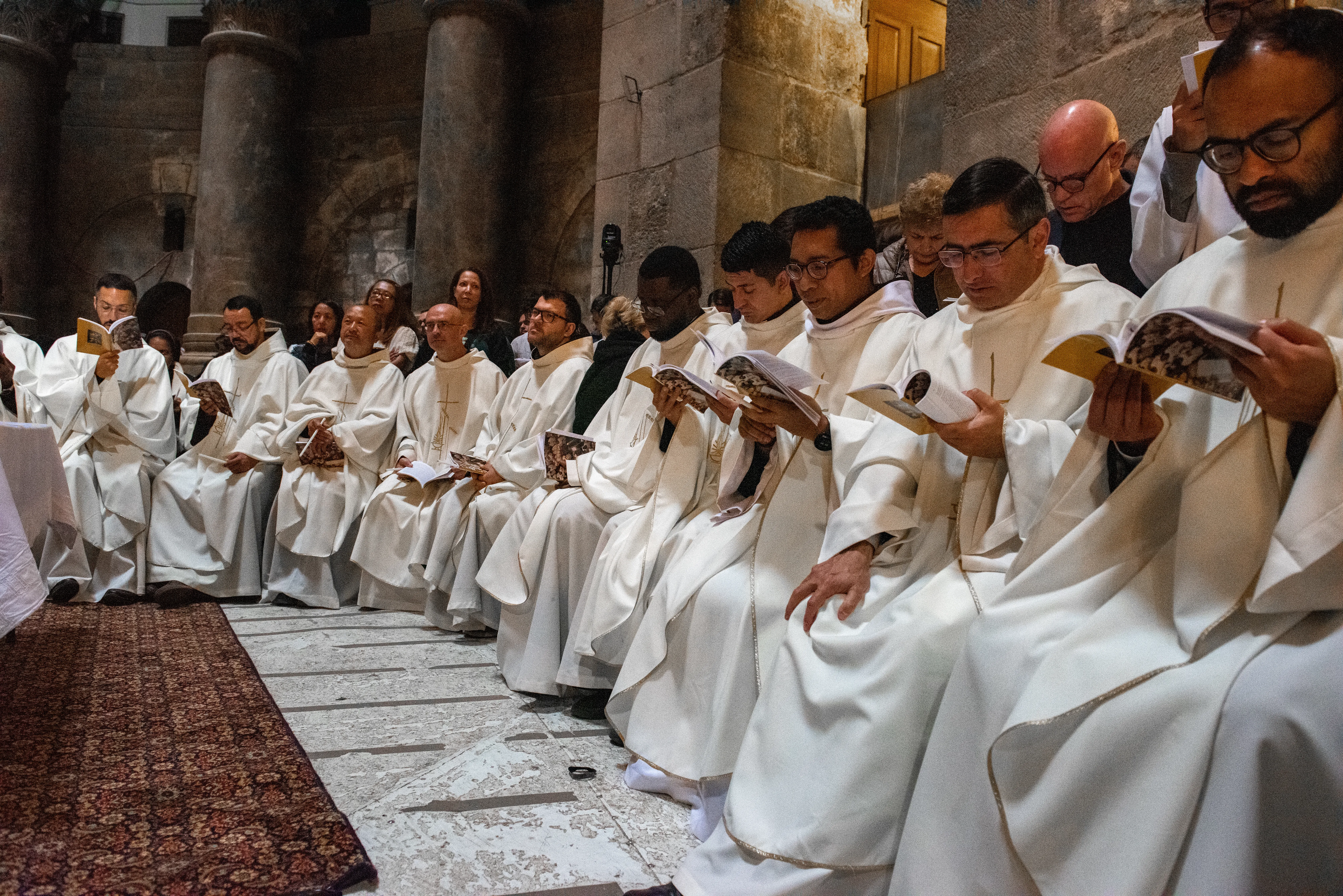 A group of priests, dressed in white liturgical vestments, participate in the Easter Vigil in the Basilica of the Holy Sepulcher in Jerusalem, on the morning of Saturday, March 30, 2024.