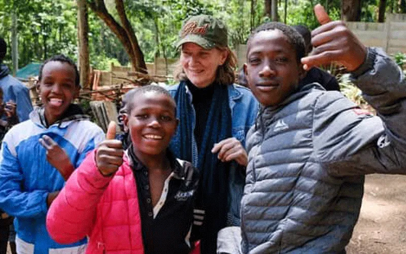Street children that are part of the Nairobi-based Alfajiri Street Kids Art pose for a photo with the founder of the facility, Australian-born Lenore Boyd (at the back) / Joost Bastmeijer for Beyond the Orphanage