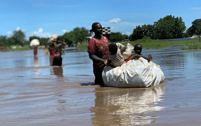Heavy rain and severe flooding in South Sudan, last week have caused severe damage to camps for refugees and internally displaced persons. Thousands of people, such as this mother and her children, have been forced to seek higher ground. / Jesuit Refugee Service.