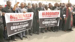 Christians hold signs as they march on the streets of Abuja during a prayer and penance for peace and security in Nigeria on March 1, 2020.