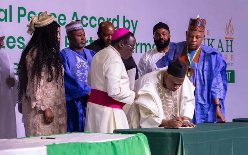 Bishop Matthew Hassan Kukah oversees the signing of the peace accord by candidates at the Abuja International Conference Center. Credit: Courtesy Photo