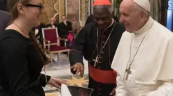 Molly Burhans presents one of her maps to Pope Francis and Cardinal Peter Turkson at the Vatican during summer 2018. Vatican Media
