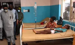 State officials walk past injured victims on hospital beds being treated for wounds following an attack by gunmen at St. Francis Xavier Catholic Church in Owo, southwest Nigeria, on June 5, 2022. | AFP via Getty Images