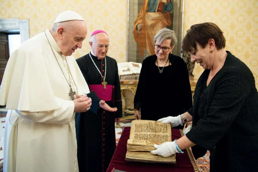Pope Francis is presented with an Aramaic prayer manuscript at the Vatican Feb. 10, 2021. Photo credits: Vatican Media/Ufficio Stampa FOCSIV.