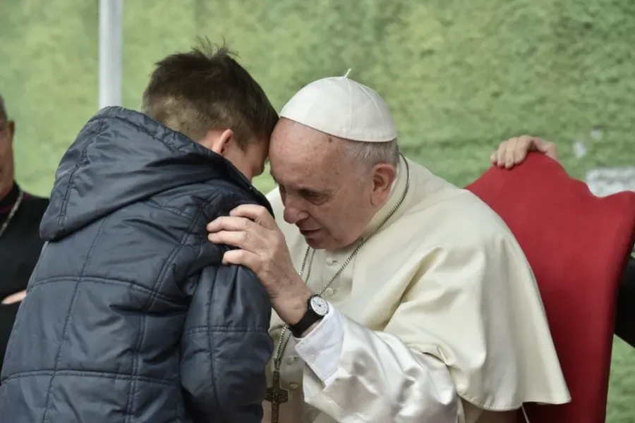 Pope Francis listens to a boy called Emanuele at St. Paul of the Cross parish, Rome, on April 15, 2018. Vatican Media.