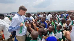 Asher Kaufman with school children in Rwanda. Credit: Children's Rosary