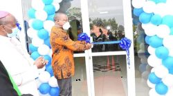Kenya's Health Cabinet Secretary, Mutahi Kagwe cuts the tape at Kiriaini Mission Hospital, marking the opening of its new ultramodern outpatient wing. Looking on is Bishop James Maria Wainaina.