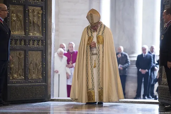Pope Francis prays after opening the Holy Door in St. Peters Basilica Dec. 8, 2015 launching the extraordinary jubilee of mercy. LOsservatore Romano.