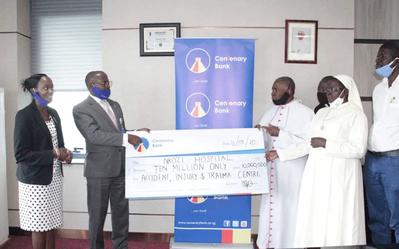 Centenary Bank Managing Director Fabian Kasi (2nd Left), Centenary , handing over a dummy cheque worth UGX10 million (US$2,700.00)  to the Nkozi Hospital Team.