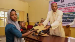 Bishop Stephen Dami Mamza presenting the sum of 150,000 Naira to one of the Victims of Boko Haram Insurgency. Credit: Yola Diocese
