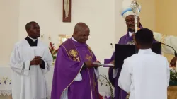 Bishop Maurício Agostinho Camuto hands Parish documents to Fr. Francisco Lumwangano. Credit: Rádio Ecclésia Caxito