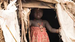 A little girl of Ethiopia's Desanetch tribe poses at the entrance of a makeshift house/ Credit: Aid to the Church in Need
