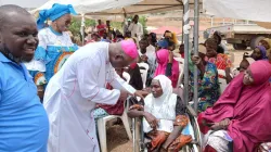 Archbishop Ignatius Ayau Kaigama of Nigeria’s Catholic Archdiocese of Abuja with one of the beneficiaries. Credit: Catholic Archdiocese of Abuja