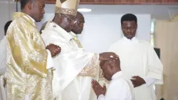 Archbishop Ignatius Kaigama lays hands on one of the Deacons he was about to ordain a Priest. Credit: Archdiocese of Abuja/Facebook