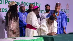 Bishop Matthew Hassan Kukah oversees the signing of the peace accord by candidates at the Abuja International Conference Center. Credit: Courtesy Photo