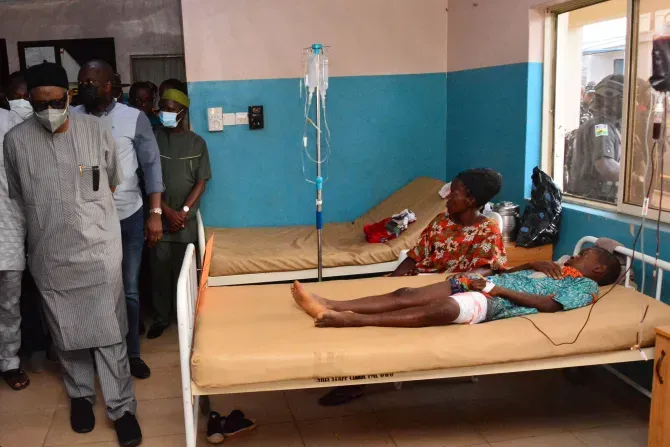 State officials walk past injured victims on hospital beds being treated for wounds following an attack by gunmen at St. Francis Xavier Catholic Church in Owo, southwest Nigeria, on June 5, 2022. | AFP via Getty Images