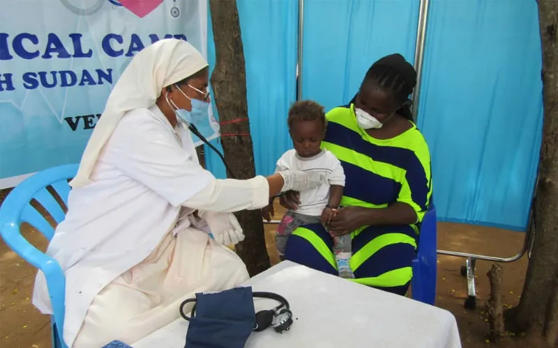 A member of the Society of Daughters of Mary Immaculate and collaborators providing healthcare assistance to a little child / ACI Africa