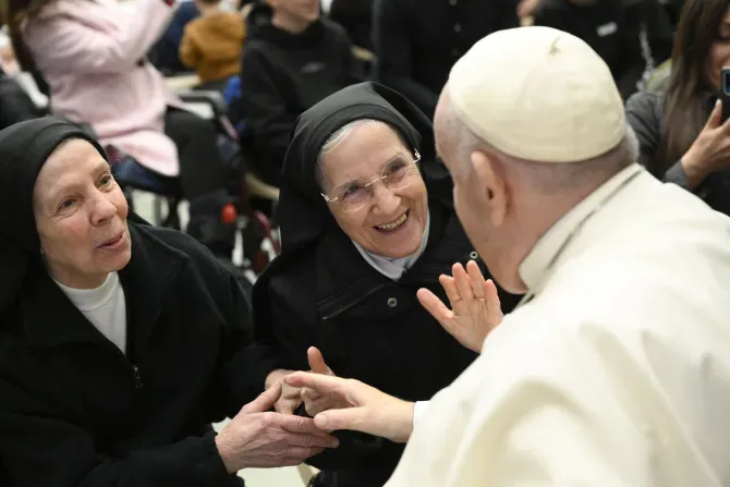Pope Francis smiles with two religious sisters during his general audience on Jan. 11, 2023 | Vatican Media