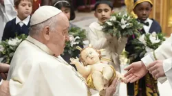 Pope Francis takes a figure of the Christ child in his arms at the end of the Vatican's Mass for the Nativity of the Lord on Dec. 24, 2023. | Vatican Media