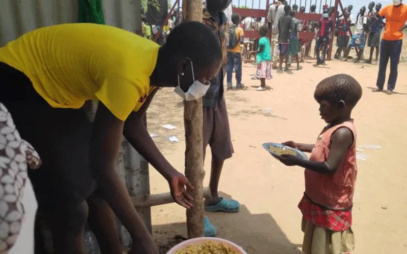 A volunteer serves food to children at Don Bosco Gumbo IDP camp, Juba. / Salesians of Don Bosco