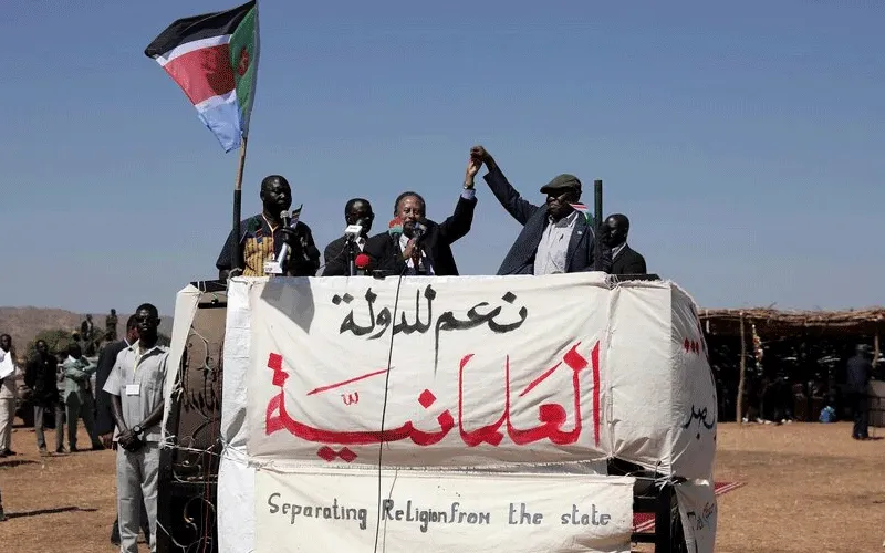 Sudanese Prime Minister Abdalla Hamdok, left, and The Sudan Liberation Movement-North leader, Abdel-Aziz Adam al-Hilu, hold up their hands in the conflict-affected remote town of Kauda, Nuba Mountains, Sudan, Jan. 9, 2020. / AFP