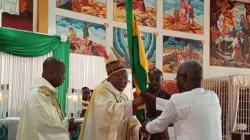 Archbishop Emeritus of Lome, Philippe Fanoko Kpodzro hands over the Togolese flag to Messan Agbeyomé Kodjo, one of the presidential candidates on February 1, 2020. / Togo Breaking News