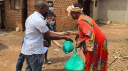 A woman in Uganda receiving food donations from members of Salesians of Don Bosco. Credit: Salesian Missions