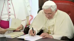 Pope Benedict XVI signs an apostolic exhortation on Nov. 19, 2011, in Benin. | Credit: Vatican Media