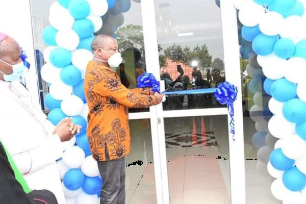 Kenya's Health Cabinet Secretary, Mutahi Kagwe cuts the tape at Kiriaini Mission Hospital, marking the opening of its new ultramodern outpatient wing. Looking on is Bishop James Maria Wainaina.