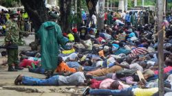 Police force ferry passengers to lie down after firing tear gas and detaining them in Mombasa, Kenya. / AFP